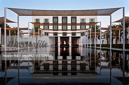 Ghubrah Masqat, Muscat, Oman. Die wichtigsten Schwimm und Poolbar im Luxus 5 Sterne Chedi Hotel Resort bei Sonnenuntergang.