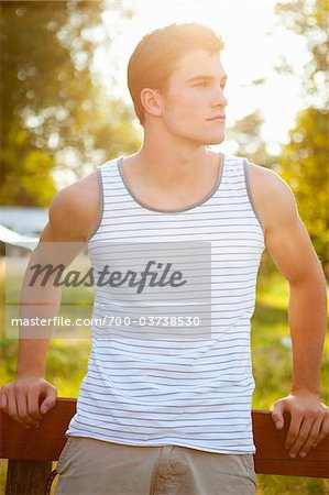 Teenage Boy Leaning Against Fence