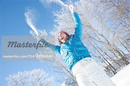 Frau wirft Schnee in der Luft
