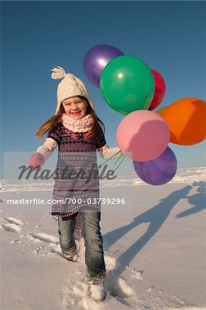 Girl Running with Balloons in Winter