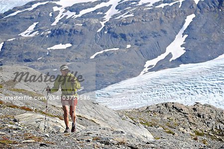 Woman hiking alongside  Exit Glacier in the Harding Icefield, Kenai Fjords National Park, Kenai Peninsula, Southcentral Alaska, Summer