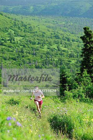 Female jogger runs the Near Point Trail in Chugach State Park near Anchorage, Southcentral Alaska, Summer