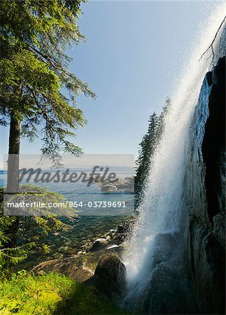 Side view of waterfall cascading down the east side of Baranof Island on a sunny day, Tongass National Forest, Inside Passage of Southeast Alaska, Summer