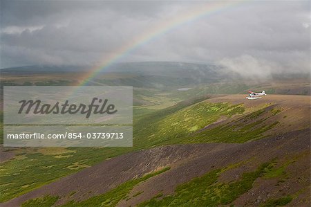 Aerial view of floatplane flying near Crystal Creek Lodge with a rainbow in the background, King Salmon, Southwest Alaska, Summer
