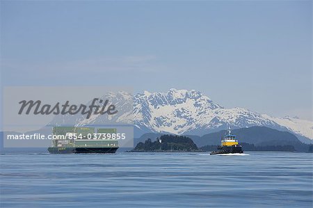 A tug pulling a barge cruises through the Inside Passage on its way south from Skagway, Alaska. Lynn Canal, Alaska Marine Lines.