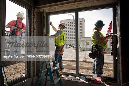 Tischler installieren Fensterrahmen bei Renovierung McKinley Tower Apartments (ehemals MacKay-Gebäude) in der Innenstadt von Anchorage, South Central Alaska, Sommer