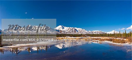 View of a small stream just starting its spring melt off the Denali Highway with the Alaska Range foothills in the background, near Cantwell, Southcentral Alaska, Spring