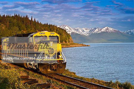 An Alaska Railroad passenger train rounds a corner along Turnagain Arm near Bird Creek, Southcentral Alaska, Summer