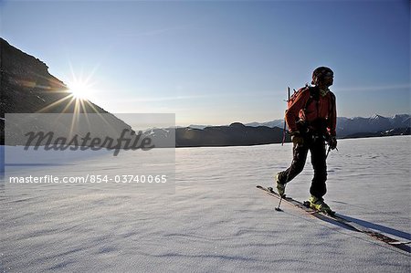 Skier dans l'arrière-pays fait une ascension matinale du côté nord du Mont Chamberlin, chaînon Brooks, ANWR, Arctique de l'Alaska, l'été