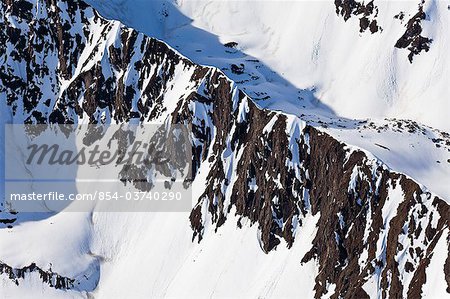 Aerial of an airplane flying along the snowcovered ridgeline of the Chugach Mountains, Chugach State Park, Southcentral Alaska, Spring