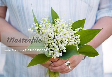 Woman with a bouquet of lilies of the valley.