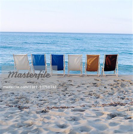 Leere Liegestühle am Strand.
