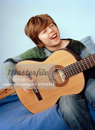 Un jeune garçon jouant de la guitare.