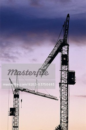 Two building cranes in a beautifylly coloured light.