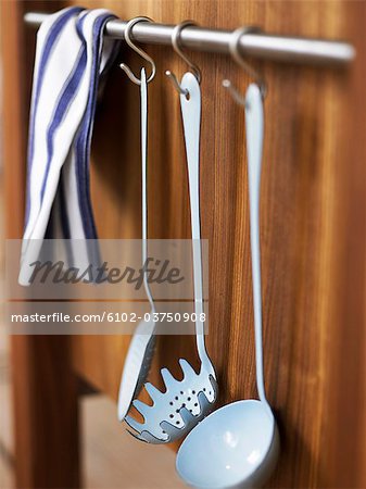 Kitchen utensils hanging in a kitchen.