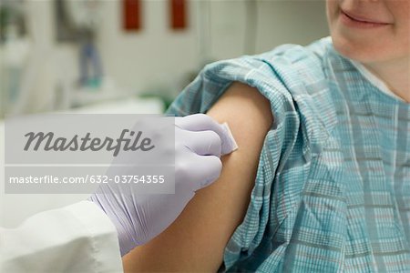 Médecin le bras du patient nettoyage avec un chiffon en préparation pour un tir