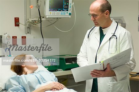 Doctor going over chart with patient in hospital