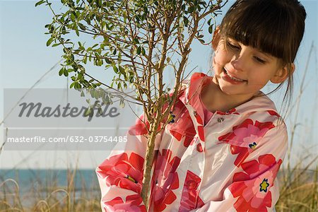 Young girl hugging tree sapling