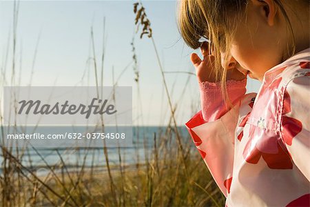 Young girl outdoors, sea in background