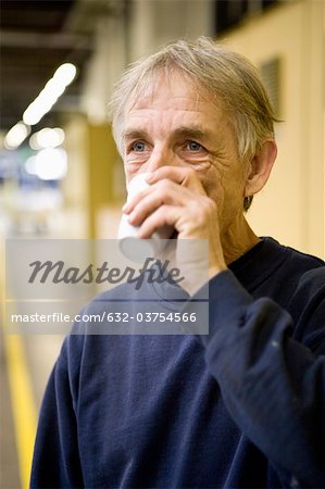 Factory worker drinking cup of coffee