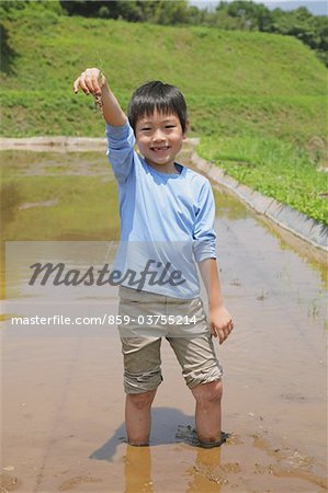 Boy Holding Plant Seed At Wetland
