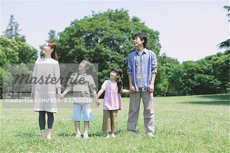 Famille japonaise à la recherche vers le haut dans un parc