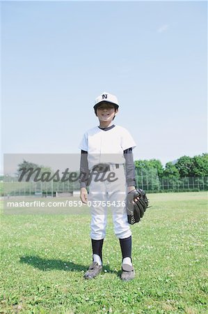 Baseball garçon debout dans le terrain de Baseball