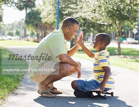 Père et fils donnant mutuellement High-Five