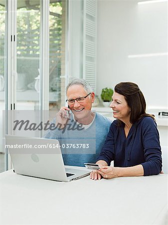 Couple mature à l'aide d'un ordinateur portable avec carte de crédit