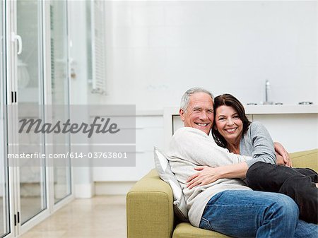 Mature couple embracing on sofa