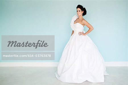 Young woman wearing white wedding dress, studio shot