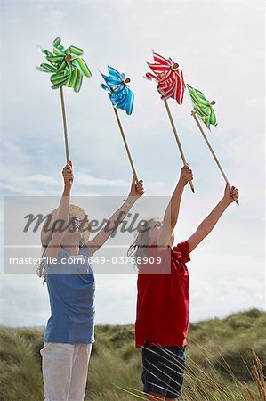 Girls holding up windmills in the sky
