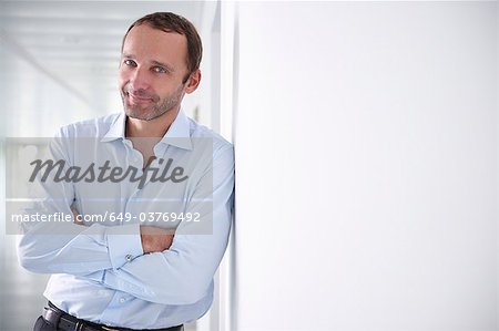 Businessman in an empty office, smiling