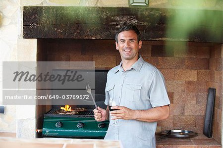 Homme souriant debout de barbecue