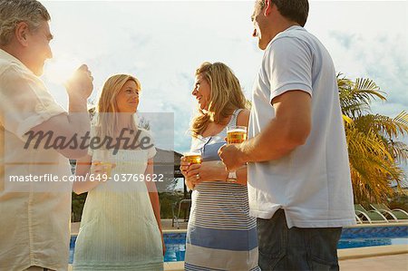 Groupe d'amis ayant des boissons au bord de piscine