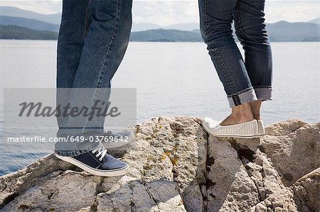Mann und Frau, stehend auf einem Felsen im Meer