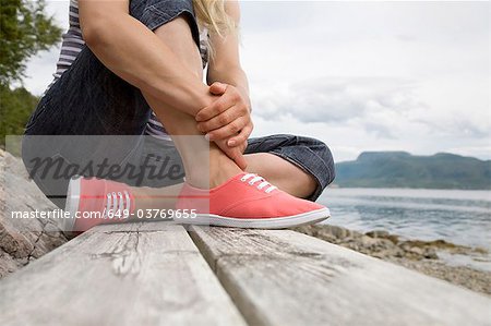 Woman sitting on bench by sea