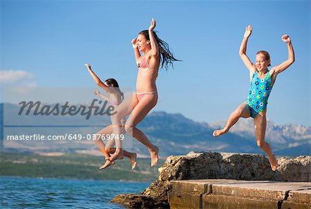 Girls jumping into water