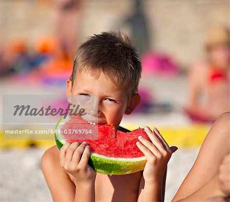 Kids eating watermelon at the beach