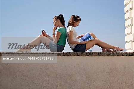 Jeunes femmes assis sur le mur