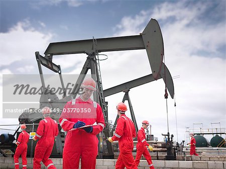Workers with oil well pumps