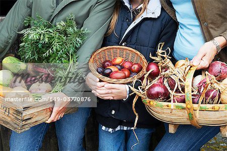 Family holding vegetables