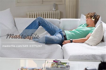 Jeune homme porte casque détend canapé