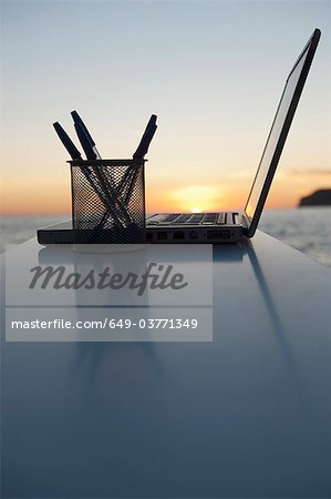 Ein Laptop mit einem Sonnenuntergang hinter