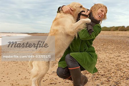 Femme de formation, de jouer avec le chien, plage