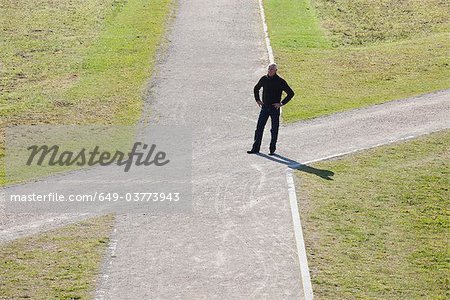 Homme debout à la croisée des chemins