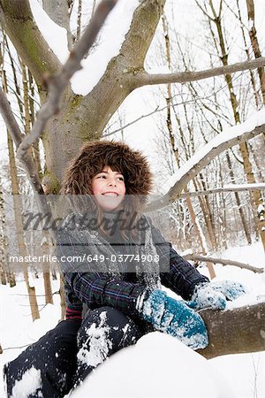 Jeune fille assise sous un arbre enneigé