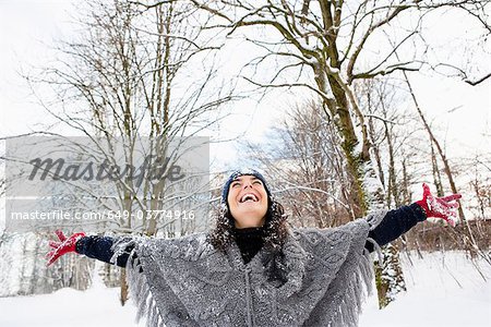 Frau in verschneiten Wäldern Himmel umarmen