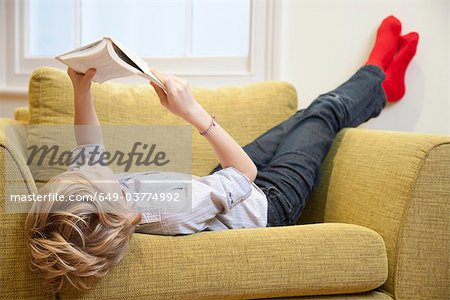 Young boy reading in an armchair