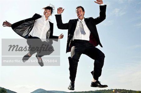 Businesswoman and businessman jumping